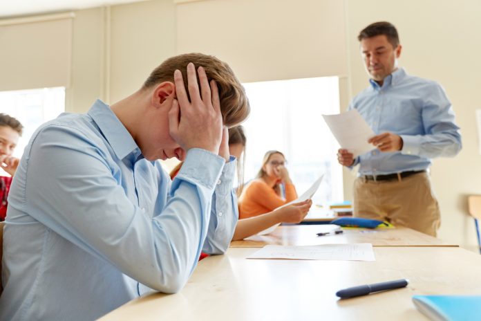 teacher giving test results to group of students