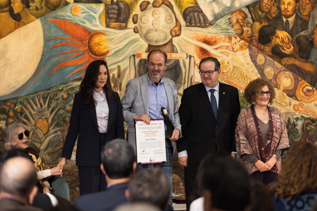 Juan Villoro recibe el Premio Carlos Fuentes 2026 junto al rector Leonardo Lomelí y la secretaria de Cultura, Claudia Curiel, en Bellas Artes.