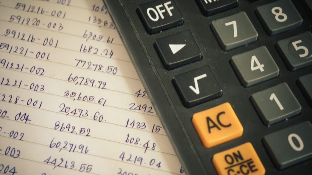 Persona revisa sus gastos y calcula el presupuesto del hogar.